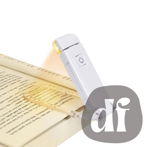 Lampe de lecture portable et rechargeable, de couleur blanche, attachée à un livre.